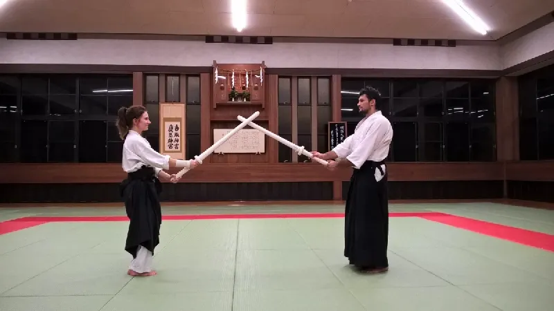 Para ćwicząca Kenjutsu z drewnianymi mieczami w dojo