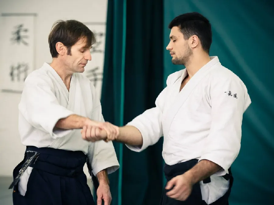 Instruktor pokazuje chwyt za nadgarstek podczas treningu Aikido